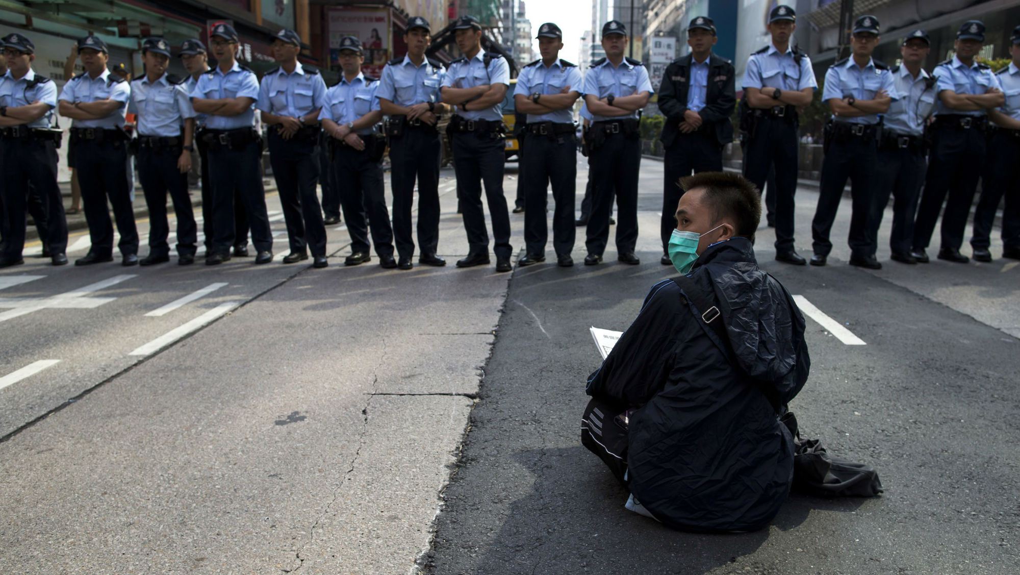 hong-kong-protests-police-protester-sitting-mk-web